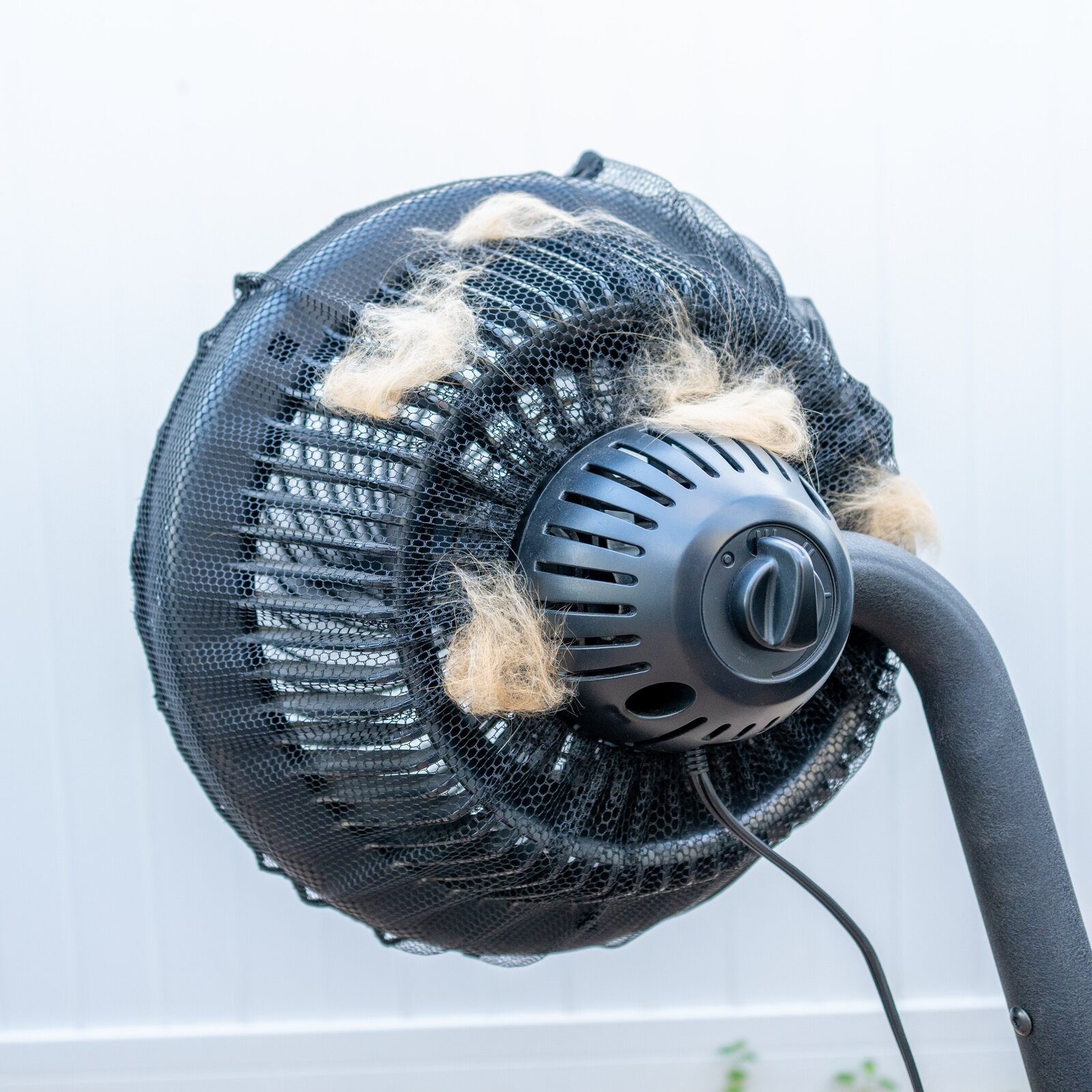 The FurStopper Fan Filter mesh visibly coated in cat hair after a few days, hair caught on the outside instead of caking on the blades inside